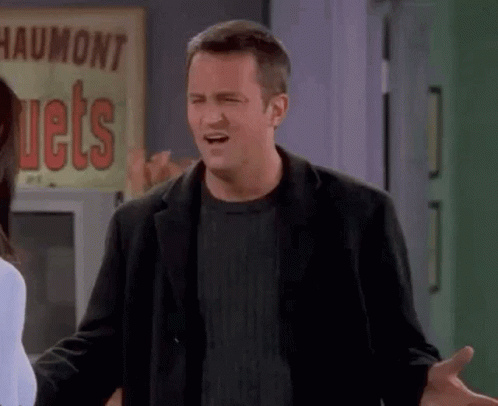 A Man In A Black Jacket Is Making A Funny Face In Front Of A Sign That Says Jets . GIF