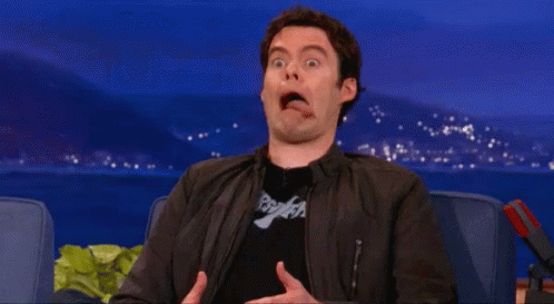 A Man In A Black Jacket Is Making A Funny Face While Sitting In A Chair . GIF