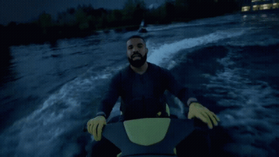 A Man In A Black Jacket Is Riding A Jet Ski GIF