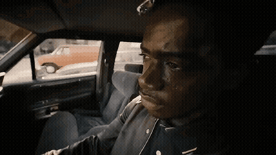 A Man In A Black Jacket Is Sitting In A Car GIF