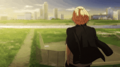 A Man In A Black Jacket Is Standing In A Field Looking At A City Skyline GIF