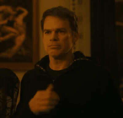 A Man In A Black Jacket Is Standing In Front Of A Painting In A Room . GIF
