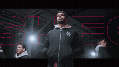 A Man In A Black Jacket Is Standing In Front Of A Sign That Says " Spec " GIF