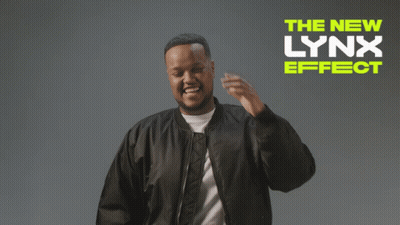 A Man In A Black Jacket Is Standing In Front Of A Sign That Says " The New Lynx Effect " GIF