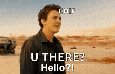 A Man In A Black Jacket Is Standing In The Desert Talking To Someone . GIF
