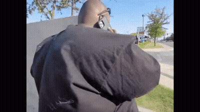 A Man In A Black Jacket Is Talking On A Cellphone GIF