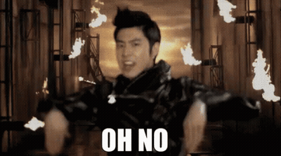 A Man In A Black Jacket Says Oh No In Front Of Fire GIF