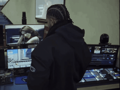 A Man In A Black Jacket Stands In Front Of A Computer Screen That Says Toronto GIF