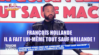 A Man In A Black Jacket Stands In Front Of A Sign That Says Francois Hollande GIF