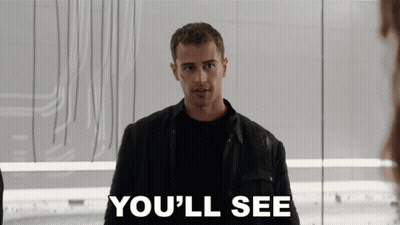 A Man In A Black Jacket Stands In Front Of A Sign That Says " You 'Ll See " GIF