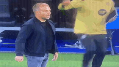 A Man In A Black Jacket Stands Next To A Man In A Yellow Nike Shirt GIF