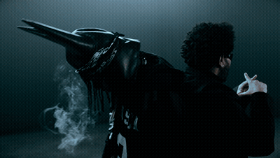 A Man In A Black Jacket With The Letter P On The Back Is Smoking A Cigarette GIF