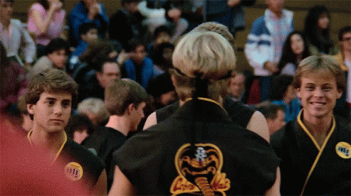 A Man In A Black Karate Uniform Has A Sticker On His Chest That Says Karate GIF