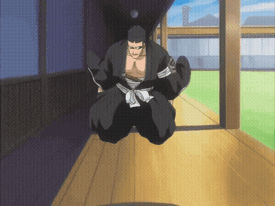 A Man In A Black Kimono Is Kneeling Down On A Wooden Floor GIF