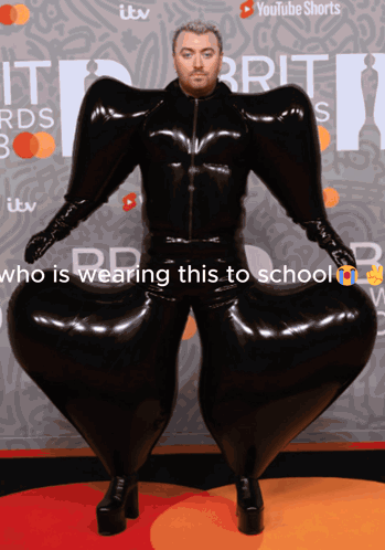 A Man In A Black Latex Suit Is Wearing A Youtube Shorts Ad Behind Him GIF