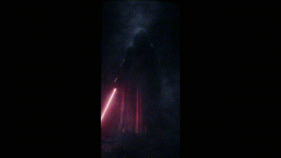 A Man In A Black Robe Holding A Red Light Saber GIF