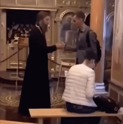 A Man In A Black Robe Is Shaking Hands With A Woman In A White Jacket GIF