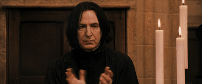 A Man In A Black Robe Stands In Front Of Candles GIF