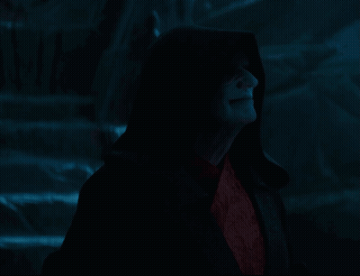 A Man In A Black Robe With A Hood And Red Eyes GIF