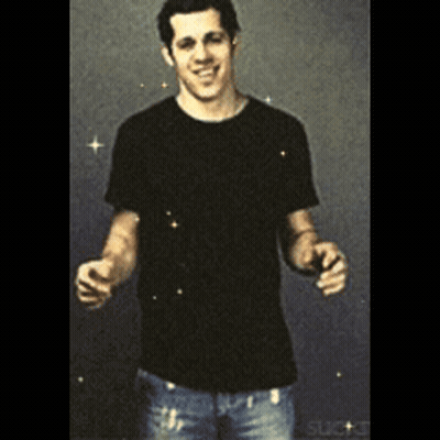 A Man In A Black Shirt And Jeans Is Standing With His Arms Outstretched And Smiling GIF