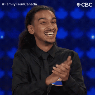 A Man In A Black Shirt And Tie With A Name Tag That Says Raheem GIF