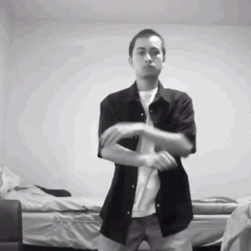 A Man In A Black Shirt And White T-Shirt Is Dancing GIF