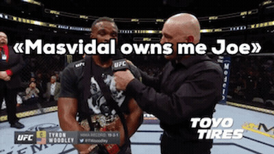 A Man In A Black Shirt Is Being Interviewed By A Man In A Black Shirt With A Microphone . GIF