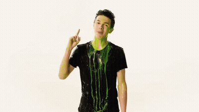A Man In A Black Shirt Is Covered In Green Slime And Dancing . GIF