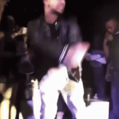 A Man In A Black Shirt Is Dancing On Stage GIF