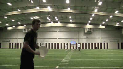 A Man In A Black Shirt Is Holding A Frisbee GIF