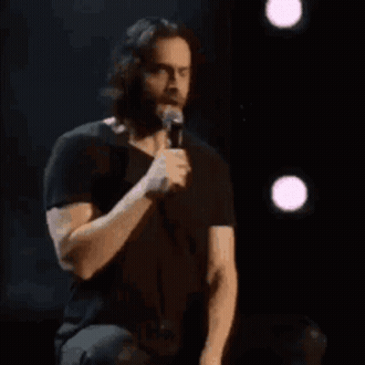 A Man In A Black Shirt Is Holding A Microphone And Says Sign Me Uppppp GIF