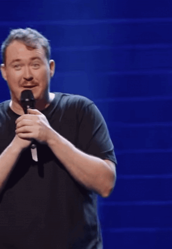A Man In A Black Shirt Is Holding A Microphone And The Word Not Bad Is On The Bottom Right GIF