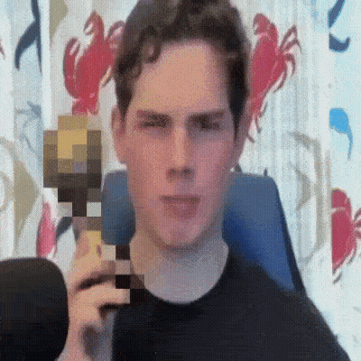 A Man In A Black Shirt Is Holding A Minecraft Block In Front Of His Face . GIF