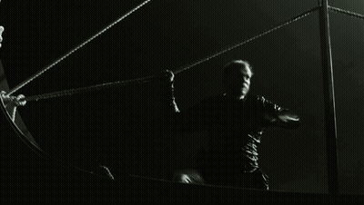 A Man In A Black Shirt Is Holding A Rope GIF
