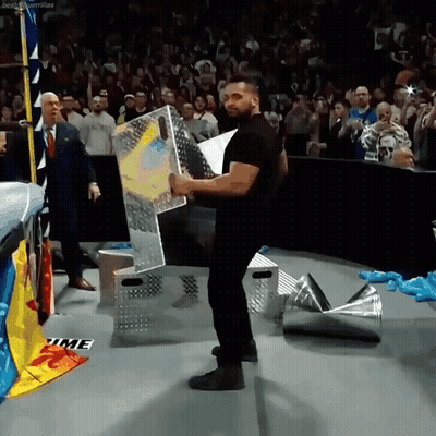 A Man In A Black Shirt Is Holding A Sign That Says Time On The Floor GIF