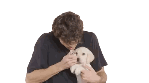 A Man In A Black Shirt Is Holding A Small White Dog Sticker