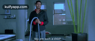A Man In A Black Shirt Is Holding A Vacuum Cleaner And Says You Are Such A Child . GIF