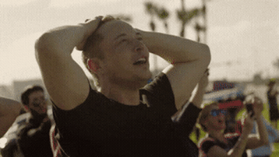 A Man In A Black Shirt Is Holding His Head In His Hands GIF