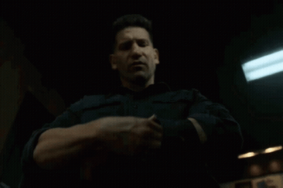 A Man In A Black Shirt Is Holding Something In His Hands GIF