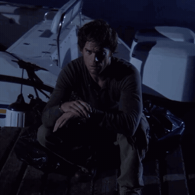 A Man In A Black Shirt Is Kneeling On A Boat In The Dark GIF