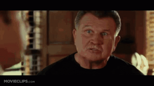A Man In A Black Shirt Is Making A Funny Face In A Movie . GIF