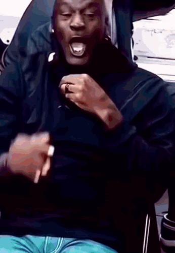 A Man In A Black Shirt Is Making A Funny Face GIF