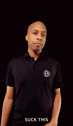 A Man In A Black Shirt Is Pointing His Fist At The Camera With The Words " Suck This " Underneath Him GIF