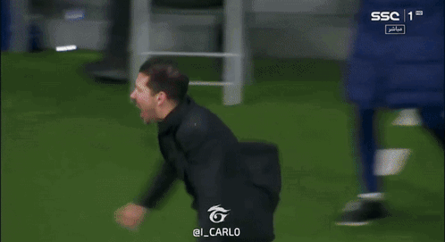 A Man In A Black Shirt Is Running On A Soccer Field GIF