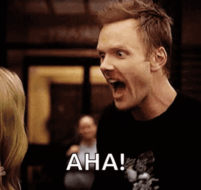 A Man In A Black Shirt Is Screaming With His Mouth Open And The Word Aha Is On The Screen Behind Him . GIF