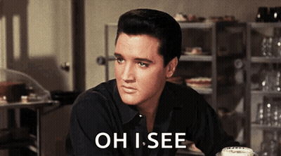 A Man In A Black Shirt Is Sitting At A Table With The Words Oh I See Above Him GIF