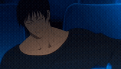 A Man In A Black Shirt Is Sitting In A Dark Room With His Arm Outstretched GIF