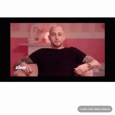 A Man In A Black Shirt Is Sitting On A Couch In Front Of A Screen That Says Zwie GIF