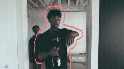 A Man In A Black Shirt Is Standing In A Doorway Holding A Bottle Of Wine . GIF