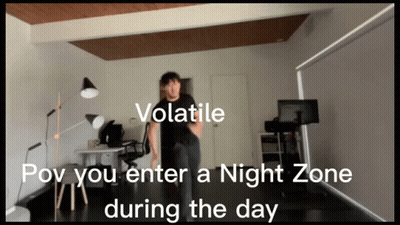 A Man In A Black Shirt Is Standing In A Room With The Words " Volatile " On The Top GIF